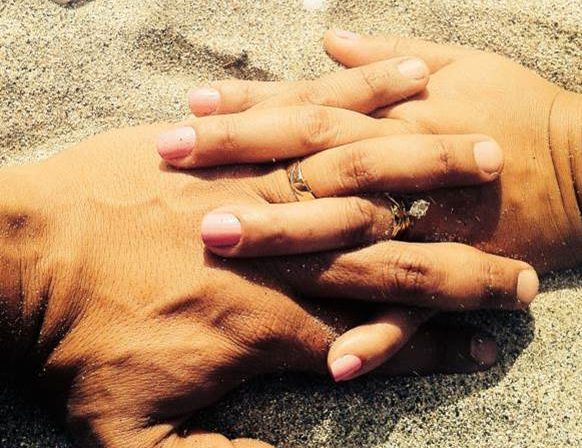 Married couple holding hands on the sand