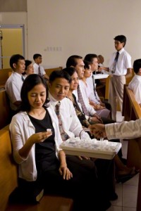a woman partaking of the sacrament during a sacrament meeting