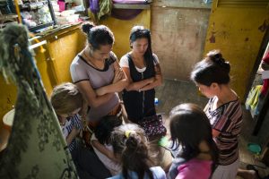 women mormon missionaries praying with family