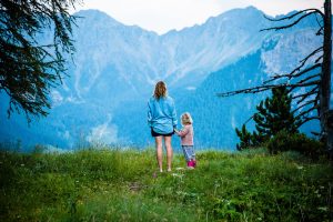 mother with daughter in nature looking at a mountain