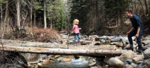 Father cheering on her daughter on a bridge in a forest