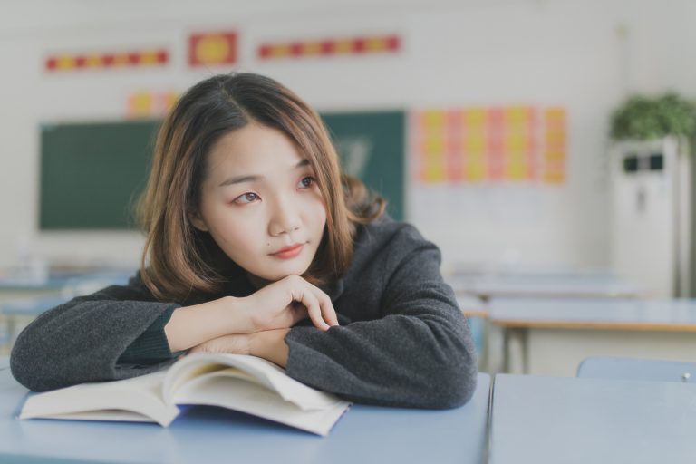 girl with book inside classroom