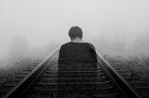 boy facing railroad head down
