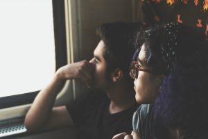 man and woman looking out the window