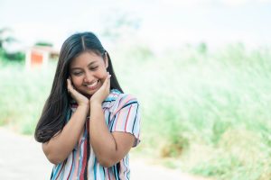 girl holding her face smiling