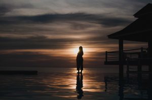 pregnant woman standing in front of a sunset