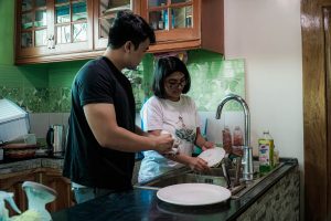 man and woman washing dishes together