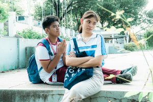 boy with hands together at the back of girl