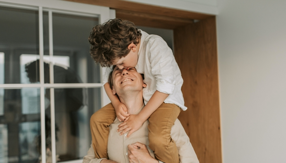 A father giving his son a piggyback ride.