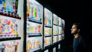 A man waiting in front of a vending machine