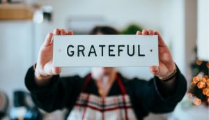 A person holding a grateful sign